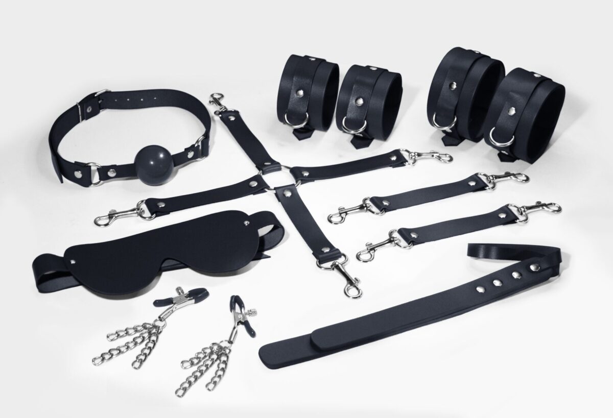 Набір Feral Feelings BDSM Kit 7 Black, наручники, поножі, конектор, маска, падл, кляп, затискачі - Зображення 1